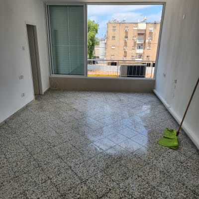 חדר ריק עם רצפה מבריקה ומגב ירוק