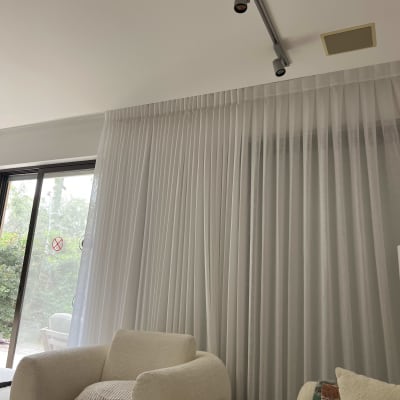 וילון לבן בסלון עם כורסאות ותאורה עליונה