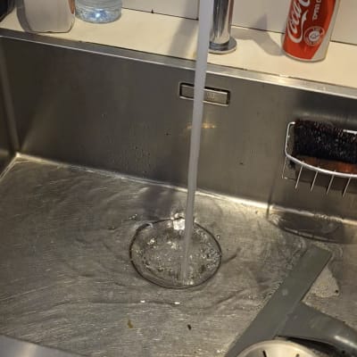 ברז מטבח עם מים זורמים בכיור נירוסטה