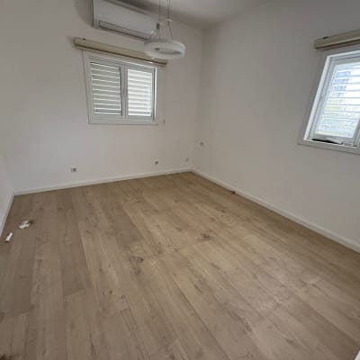 חדר ריק עם רצפת עץ וחלונות