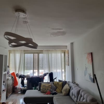 סלון עם ספה, מנורה ותקרה מתוקנת