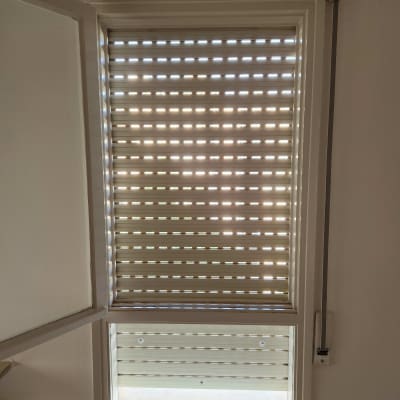 תריסים סגורים על חלון עם אור שמש חודר