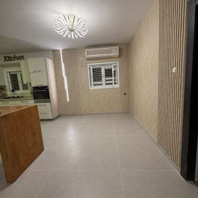 חדר עם רצפת פרקט, קיר מעוצב ותאורה מודרנית