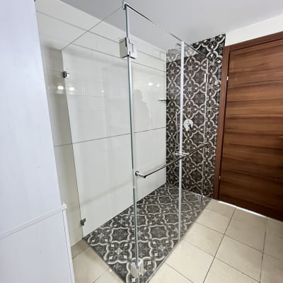 מקלחון זכוכית עם דלת עץ ורצפה מעוצבת