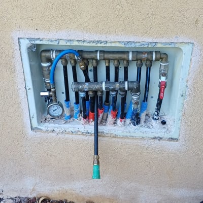 ארון מרכזיית מיםבקיר עם צנרת מרובה ושעון לחץ מים