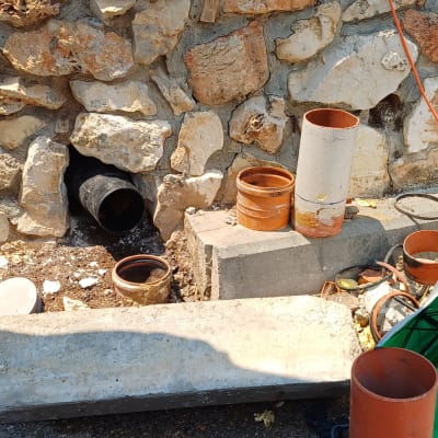 צינורות וכלי עבודה ליד קיר אבן, קשור לאינסטלציה