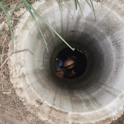 אדם בתוך צינור בטון גדול עם כלי עבודה
