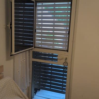 תריסים פתוחים למחצה על חלון זכוכית