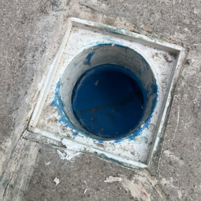 פתח ניקוז ברצפה עם צבע כחול