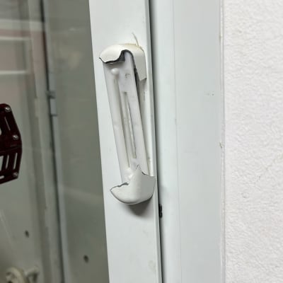 ידית תריס שבורה על מסגרת חלון לבנה