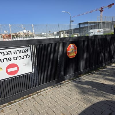 שער חשמלי עם שלט איסור כניסה לרכבים פרטיים