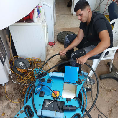 אדם עובד עם מכשיר לאיתור נזילות מים