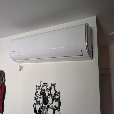 מזגן מותקן על קיר עם ציור של חתולים