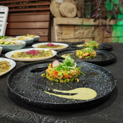 מנות שף מעוצבות על צלחות שחורות ולבנות