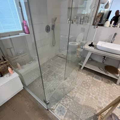 מקלחון זכוכית עם אריחים מעוצבים ושיש לבן