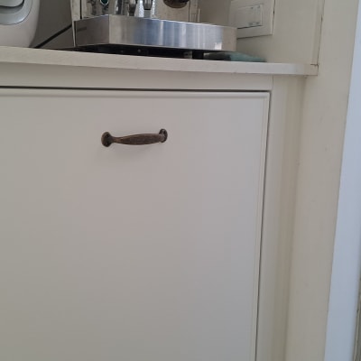 ארון מטבח עם ידית מתכת, מכונת קפה על השיש
