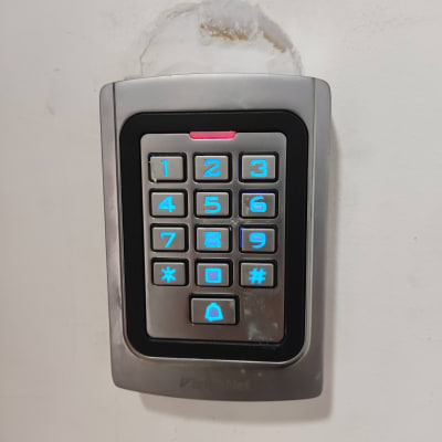 לוח מקשים עם תאורה כחולה על קיר לבן