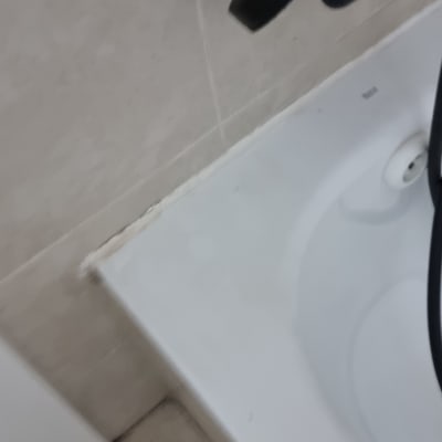 ברז שחור על קיר אריחים ליד אמבטיה