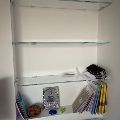 שלושה מדפי זכוכית מותקנים על קיר לבן