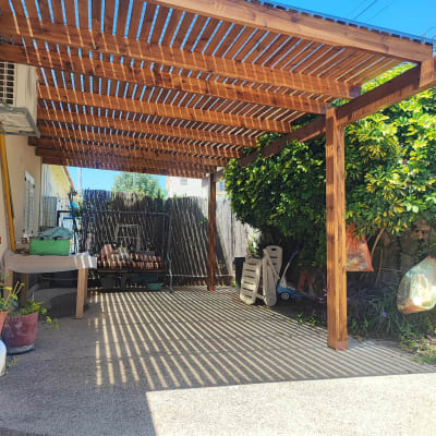 פרגולה מעץ עם צללים על הקרקע