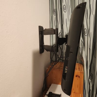 מסך מותקן על זרוע קיר בחדר עם וילון