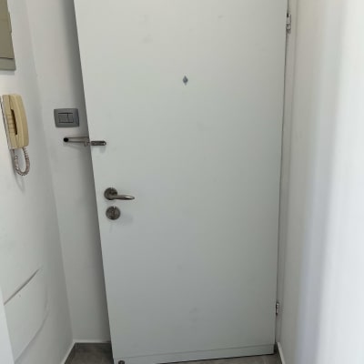 דלת לבנה עם ידית מתכת ומנעול