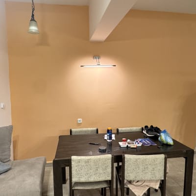 קיר צבוע בצבע כתום עם שולחן וכלים לצביעה.