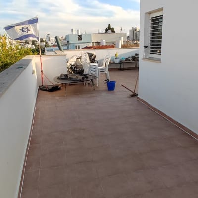 מרפסת עם דלי ומטאטא על הרצפה