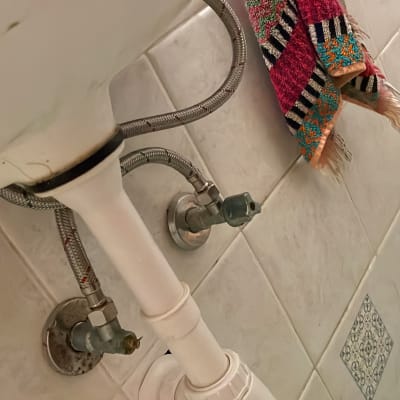 צינורות מתכת מתחת לכיור בחדר אמבטיה