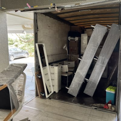 משאית הובלה עם רהיטים וארגזים עטופים בניילון