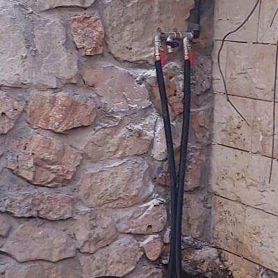 צינורות מים מחוברים לברזים על קיר אבן