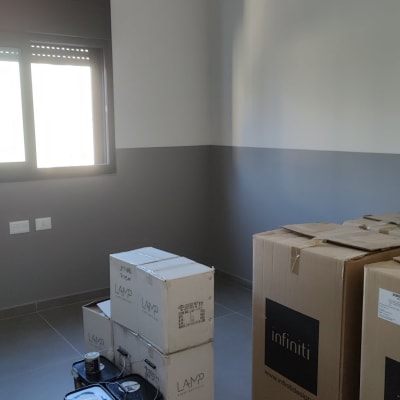 פחיות צבע וקרטונים בחדר צבוע אפור