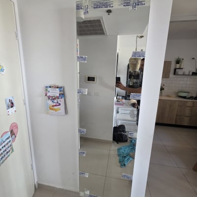 מראה גדולה על קיר בחדר עם מטבח