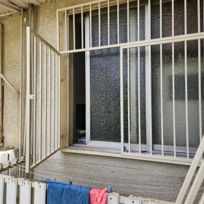 סורגים לבנים על חלון פתוח עם וילון