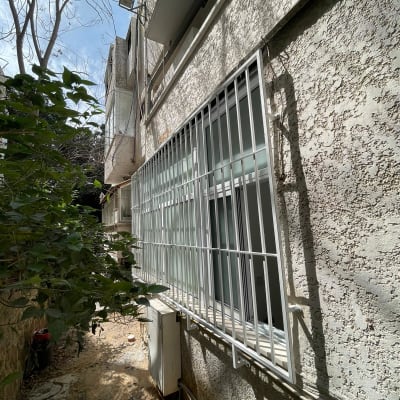 סורגי מתכת לבנים על חלון בניין