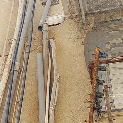 צינורות חשמל וקווי תקשורת על קיר חיצוני