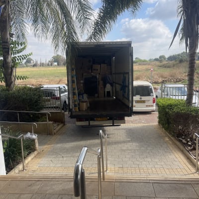 משאית הובלה עם קרטונים וחפצים מאחוריה