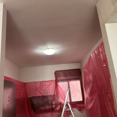 סולם וחיפוי פלסטיק אדום בעבודת שיפוץ