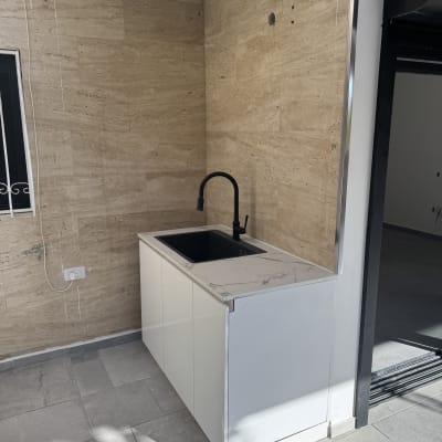 כיור עם ברז שחור על רקע קיר שיש