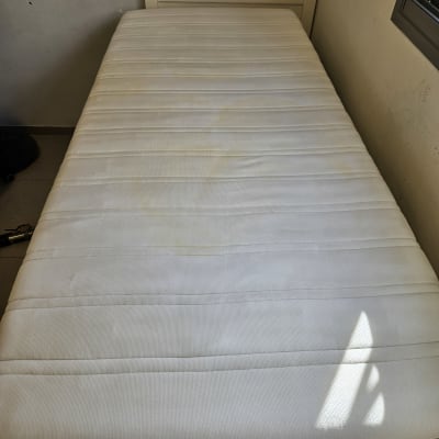 מזרן עם כתמים על משטח לבן