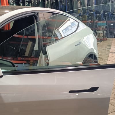 מכונית עם דלת פתוחה בחנות זכוכית לרכב