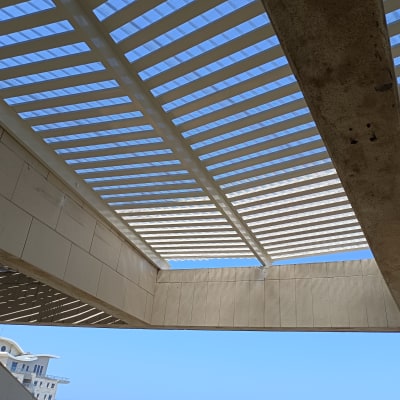 פרגולה מאלומיניום עם קורות אופקיות בשמיים כחולים