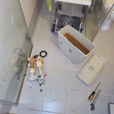 חלקי אסלה מפורקים, מברג ומפתח שוודי על הרצפה