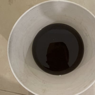 דלי עם נוזל כהה על רצפה