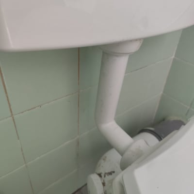 צינור לבן מחובר לאסלה בחדר אמבטיה