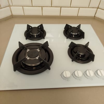 כיריים גז עם ארבעה מבערים וכפתורי שליטה לבנים