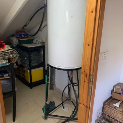 דוד שמש לבן עם צינורות בחדר קטן