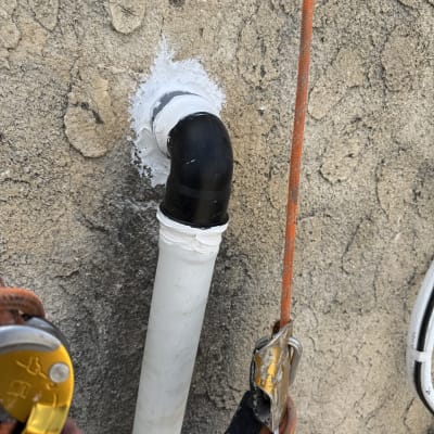 צינור עם איטום לבן על קיר בטון