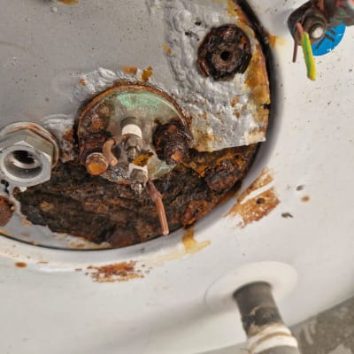 חלק תחתון של דוד שמש עם חלודה וחיבורים חשמליים