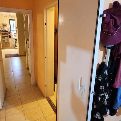 דלת לבנה פתוחה עם ידית לבנה במסדרון